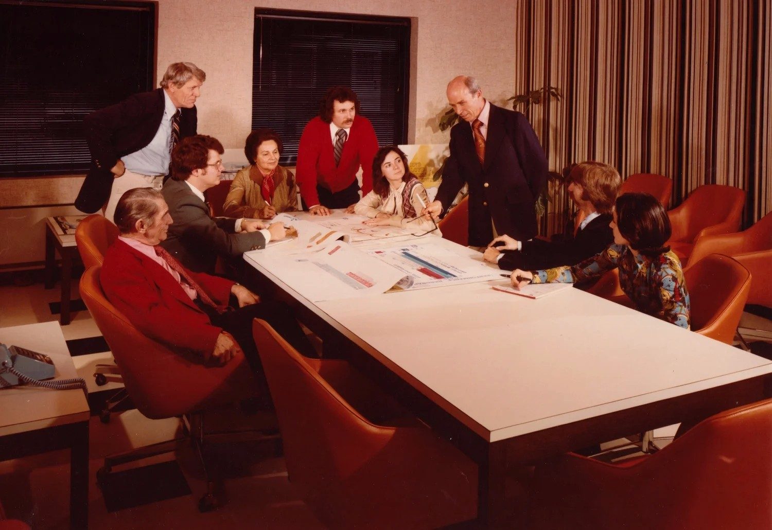 a leadership team gathered around a conference table, 1970s